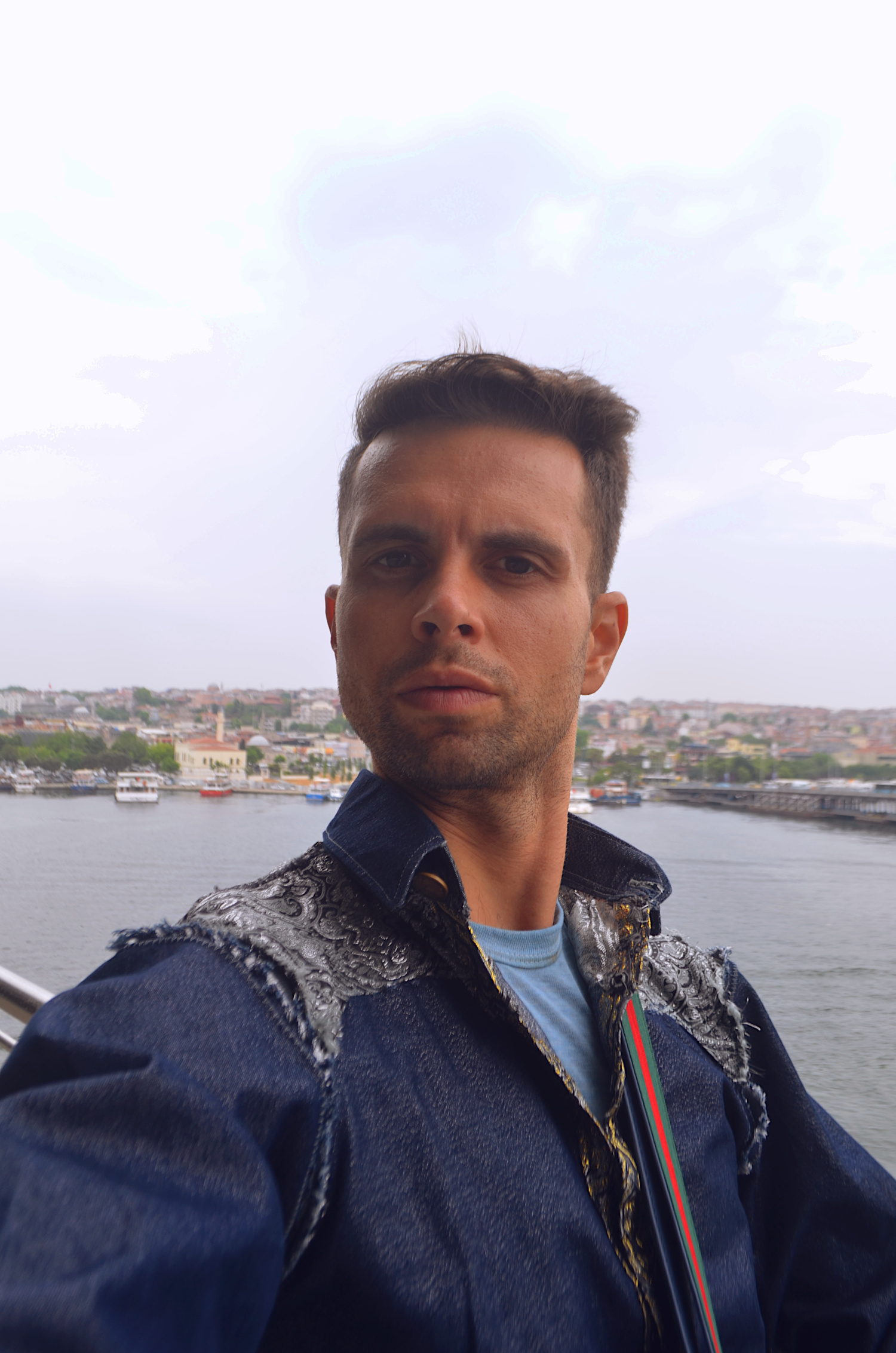 Street Style Istanbul Turkey. Cal in Gsb Wearables denim button-down shirt with brocade color blocking and frayed shoulder seams Street Style Istanbul Turkey. Cal in Gsb Wearables denim button-down shirt with brocade color blocking and frayed shoulder seams